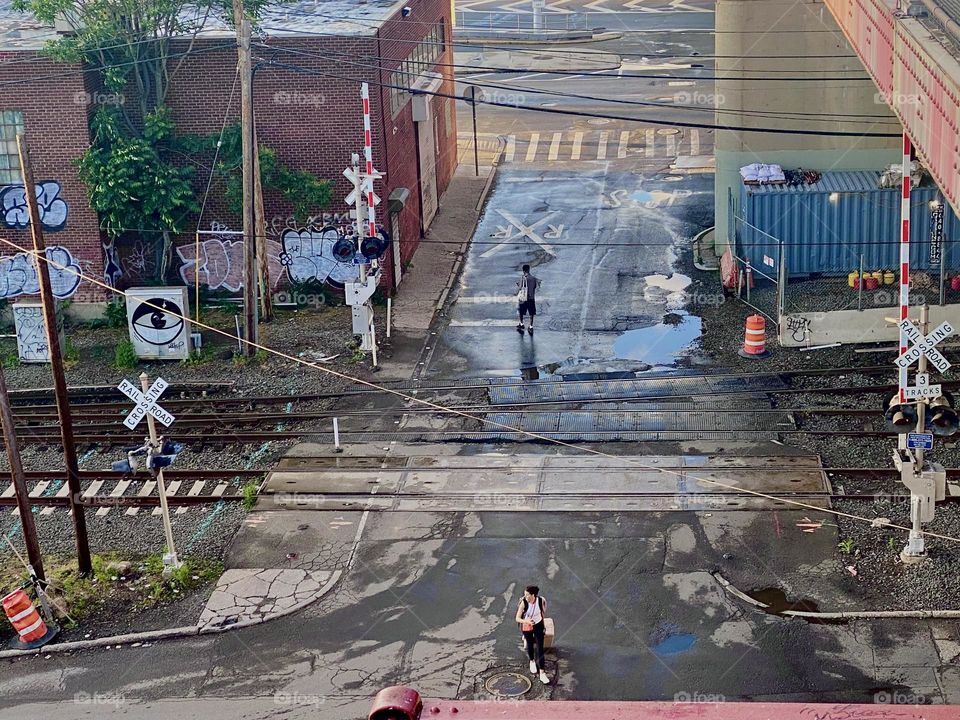 A closeup zoom in on the pedestrian crossing across the train tracks seen from the “Pulaski Bridge” in “Long Island City”, Queens. 2023. Hypnotic Productions