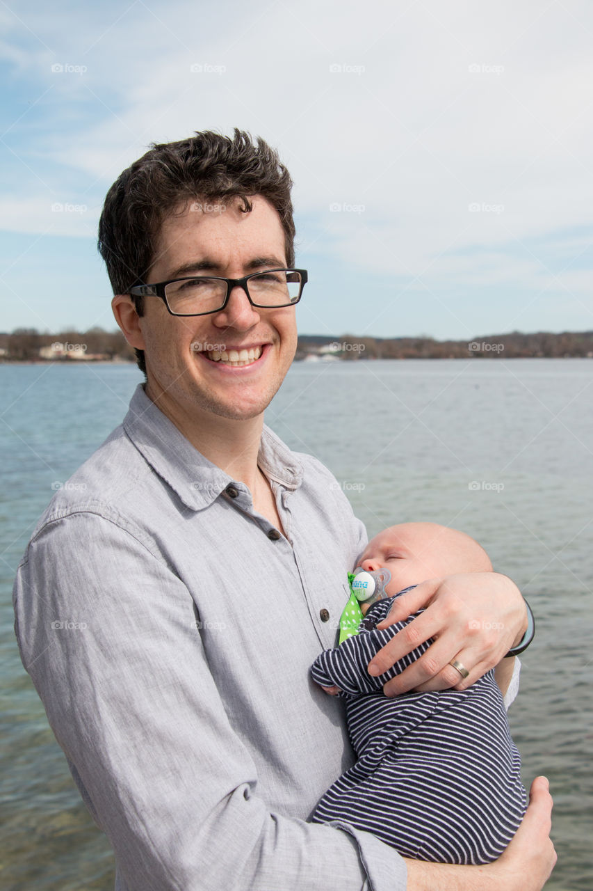 Portrait of a happy father carrying his baby