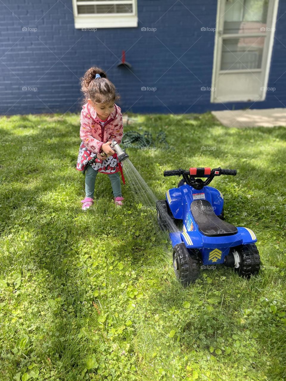 Child washes toy car, child uses hose to wash toy, cleaning up riding toy, paw patrol car cleanup 