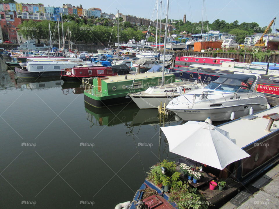 Boats all moored at Bristol floating harbour with reflection on the water