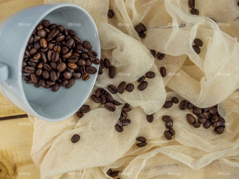 Coffee beans spilling onto the cheese cloth