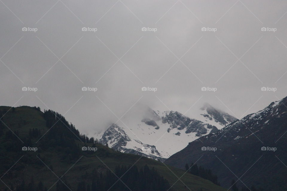 Icy mountain covering by white clouds 
