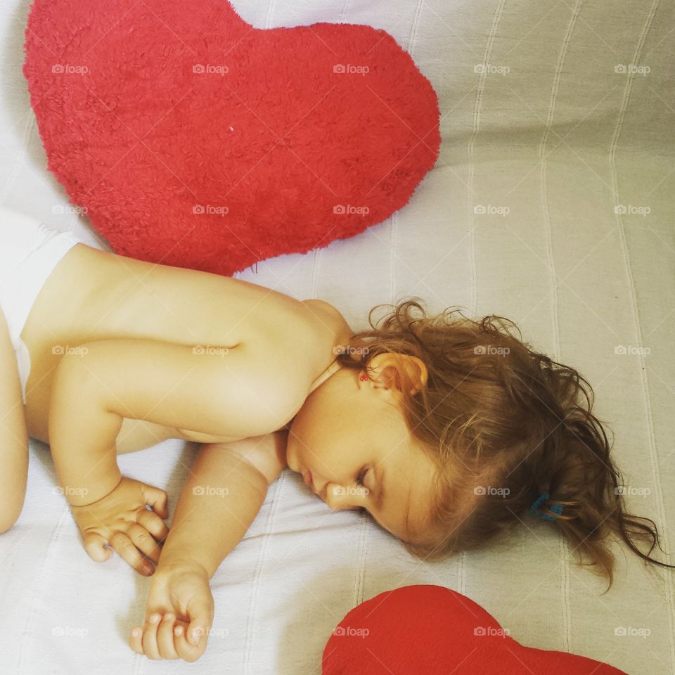 Close-up of topless child girl sleeping on bed