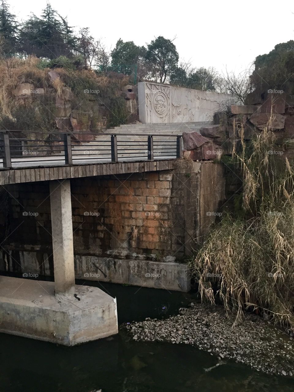 A bridge over a river with staircase and supports