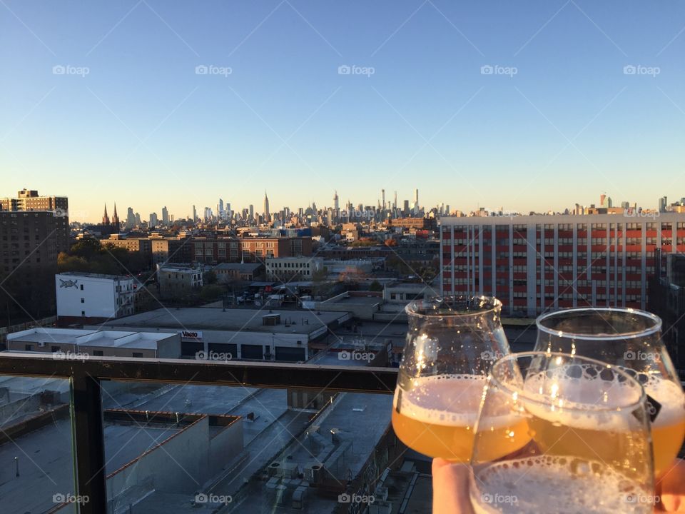 Clinking beer glasses to the Manhattan skyline