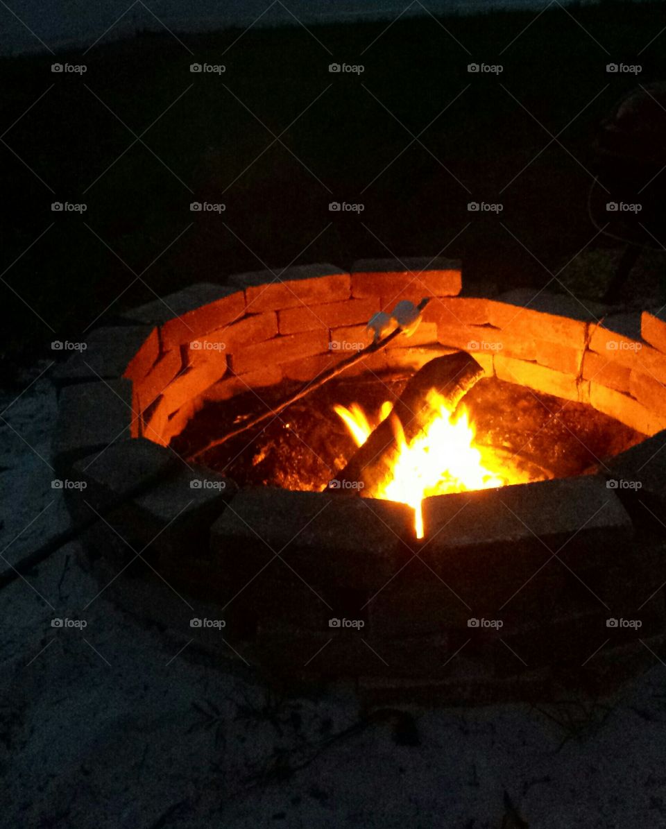 Roasting Marshmallows over a campfire.