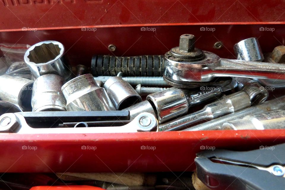 detail view of metal tools in a red colored toolbox.