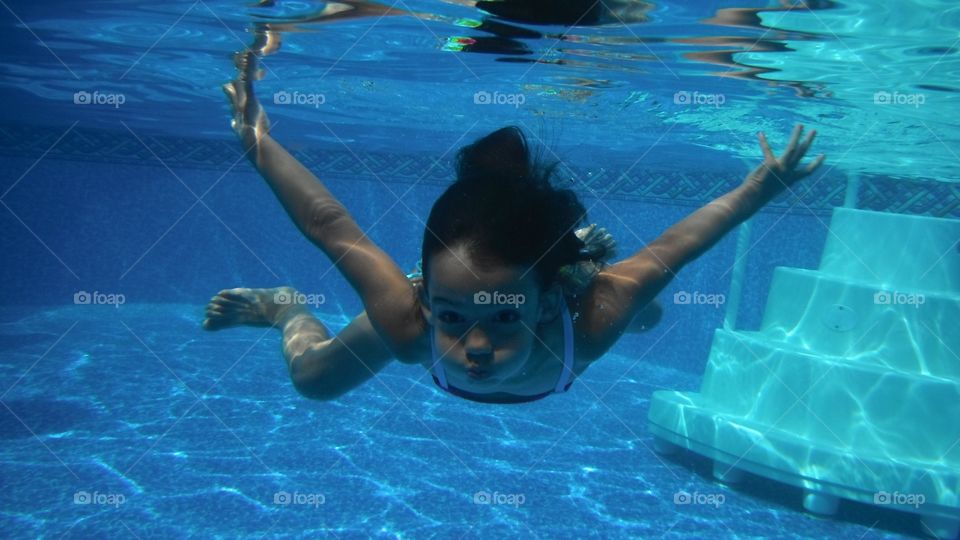 Underwater view of a girl swimming in pool