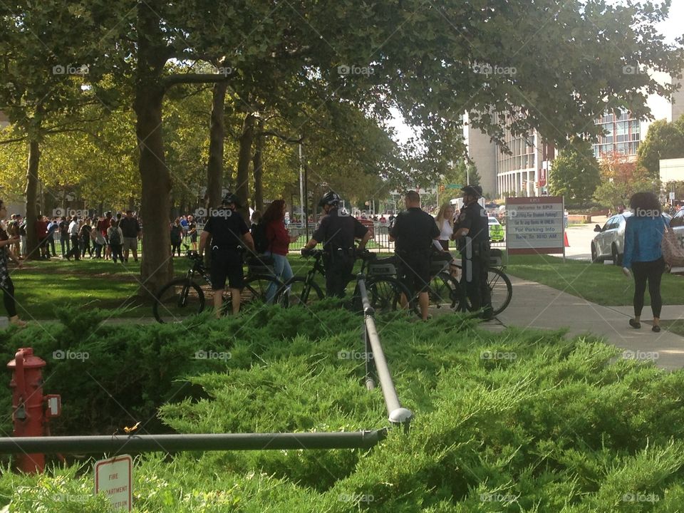 Police officers monitoring a protest. Westboro Baptist church members holding signs to protest an LGB club formed by students of IUPUI.