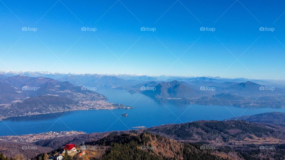 Landscapes with mountains. Area view with shades of colors, blue water and green meadows