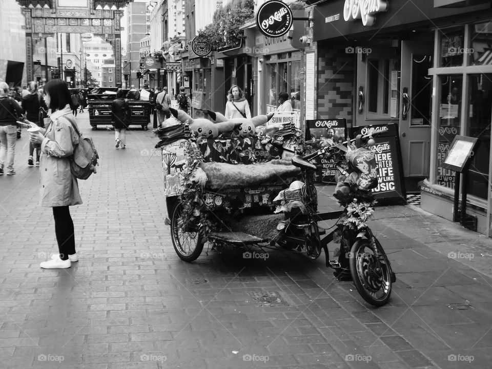 a monochrome image of London's China town and a modern rickshaw.