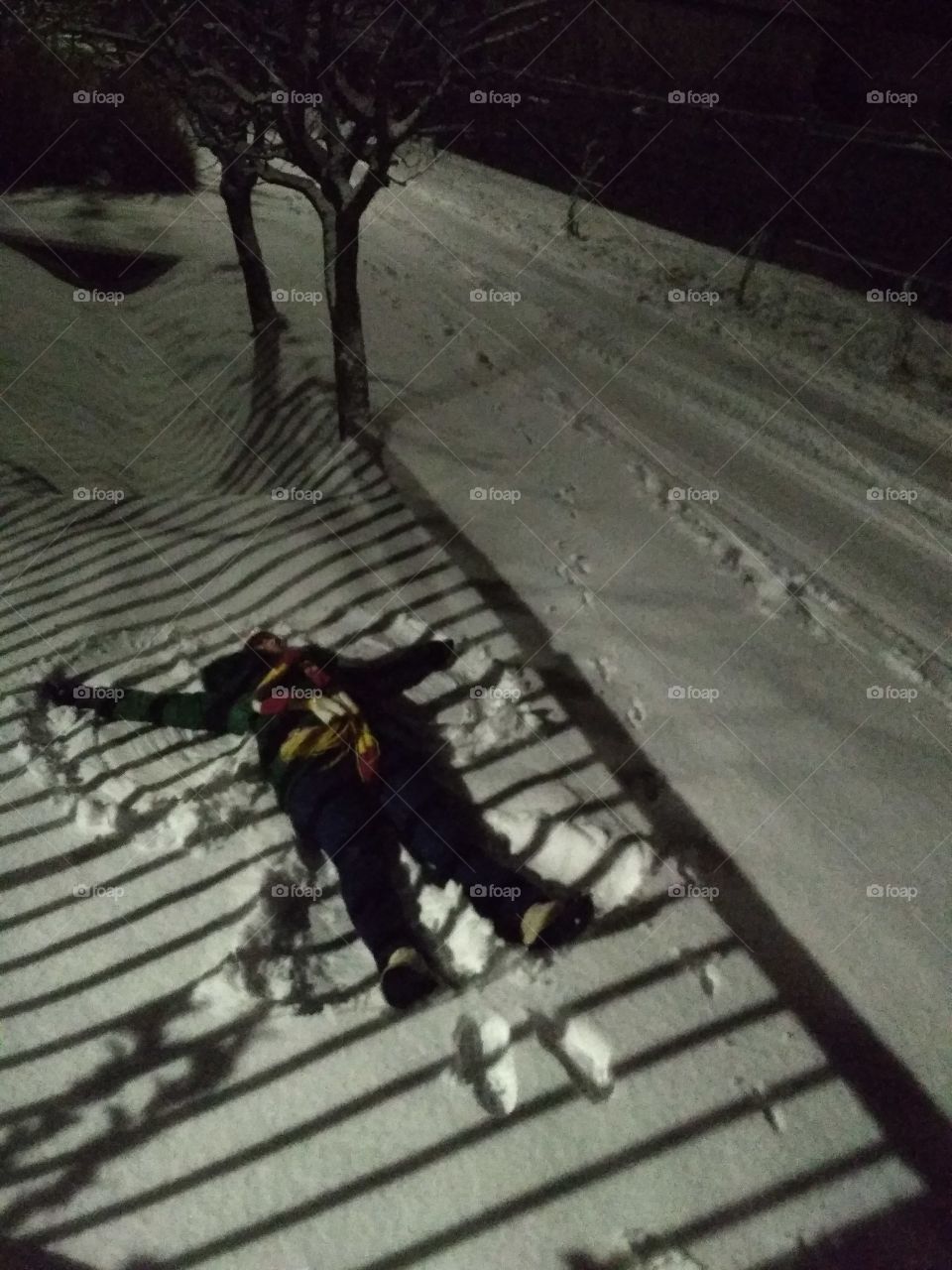 snow angel in the making on shadow-striped snow