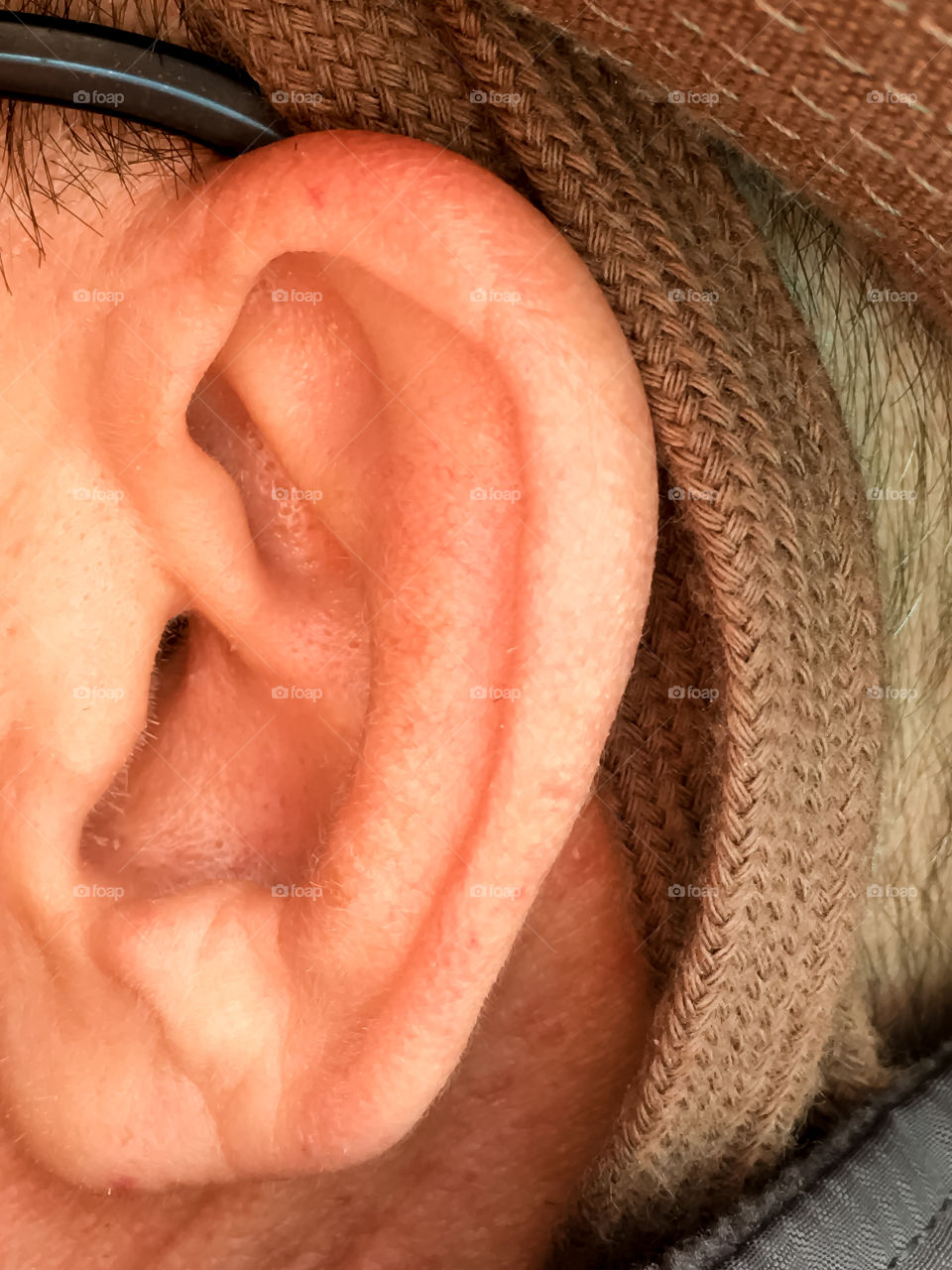 Closeup of a middle aged man's ear and canal