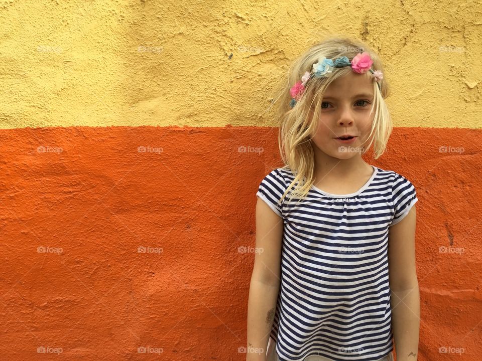Girl posing in front of a colourful wall