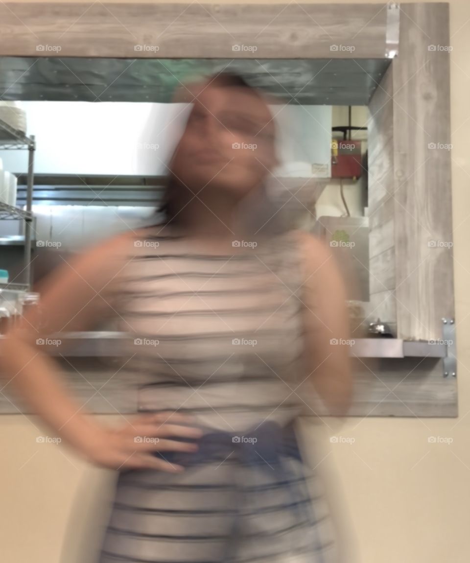 A blurry woman navigating a room. 