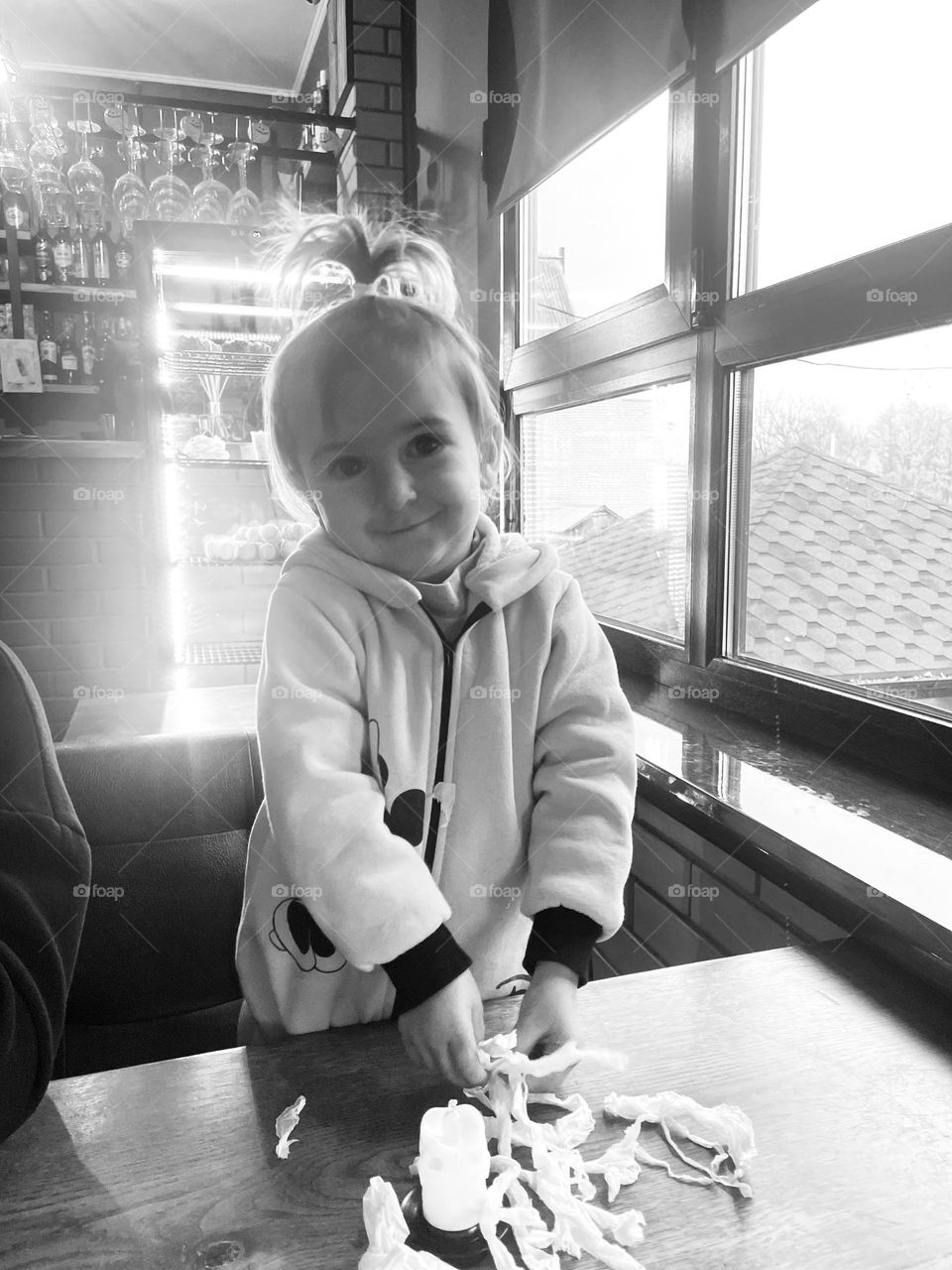 photo of a little girl against the background of a window