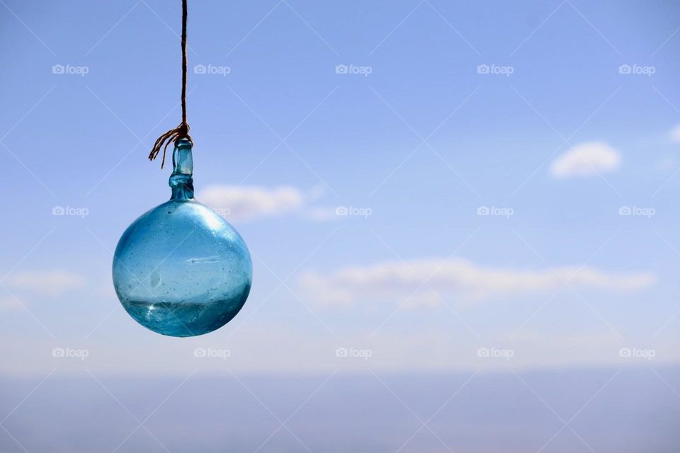 Blue glass ornament with blue sky background 