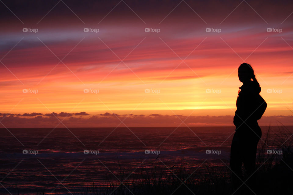 Sunset with silhouette of girl at beach
