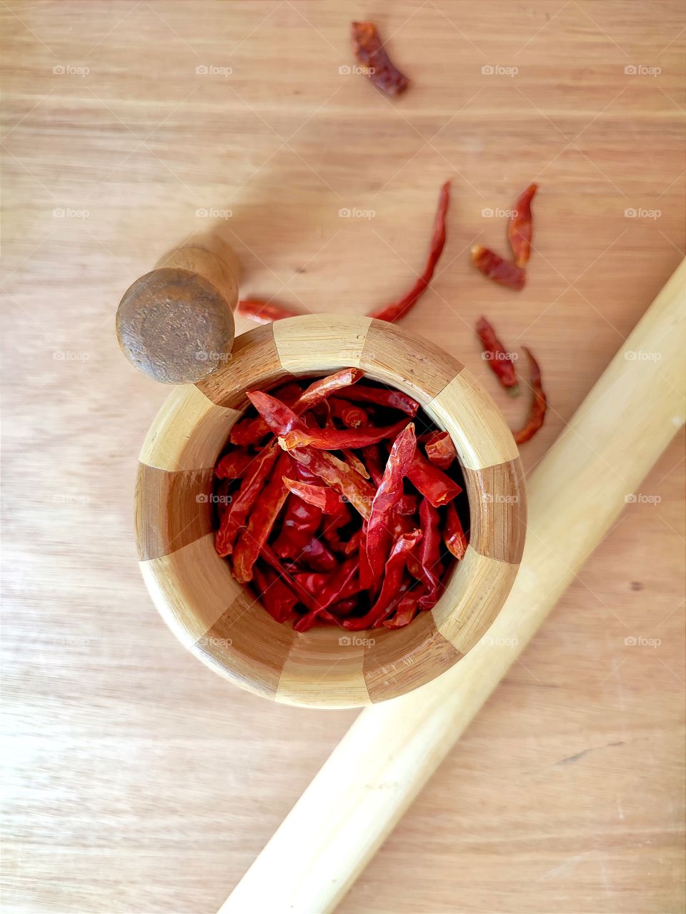 Dried red chili peppers on in a wooden mortar