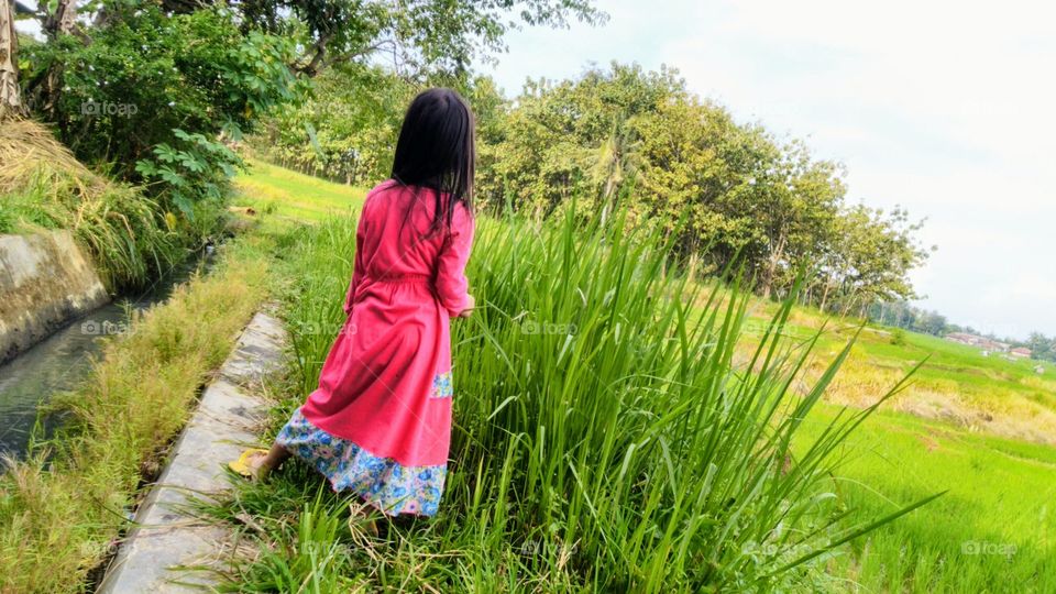 Little girl playing by the river