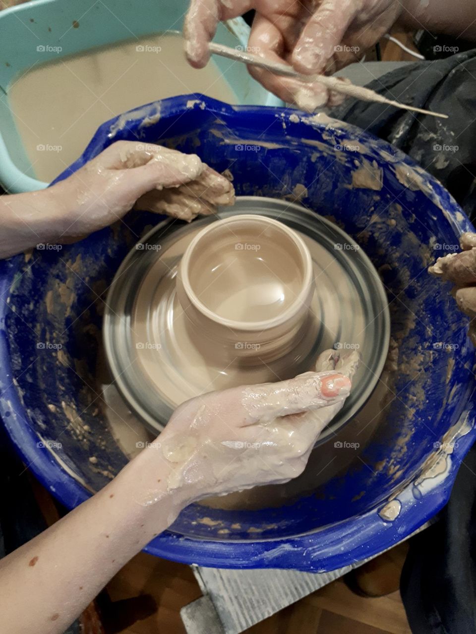 Pottery work shop. Hands doing pot from clay, top view 