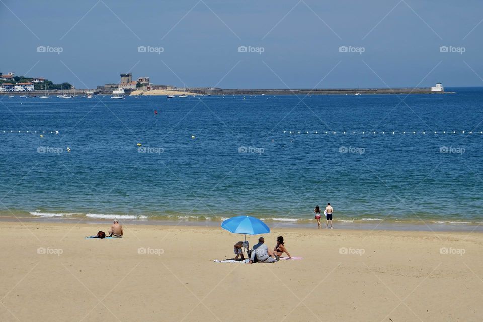Small group of people at the beach on a sunny summer day. 