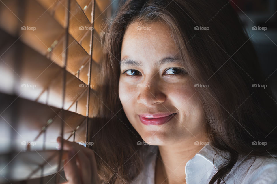 Asian women wearing a white shirt, skilling and looking