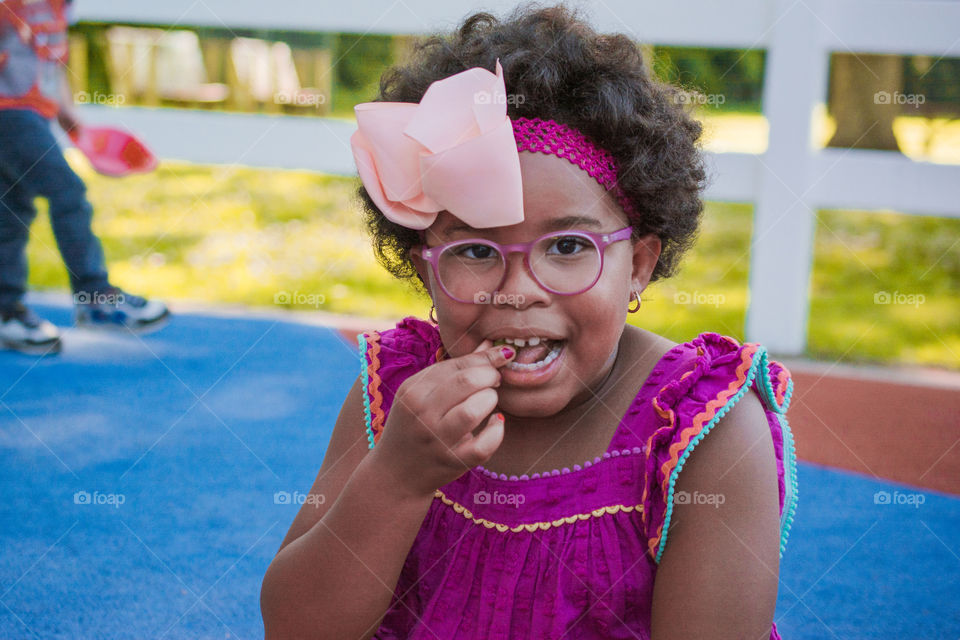 Young Girl Eating a Grape at the Park