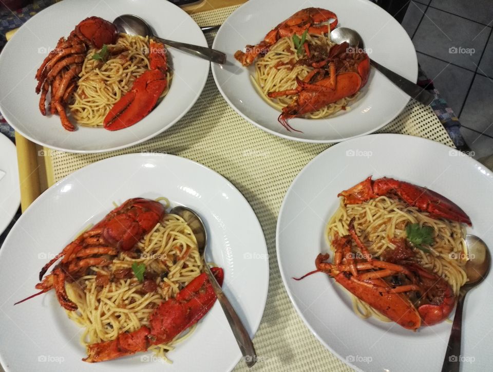 four plates spaghetti with lobster