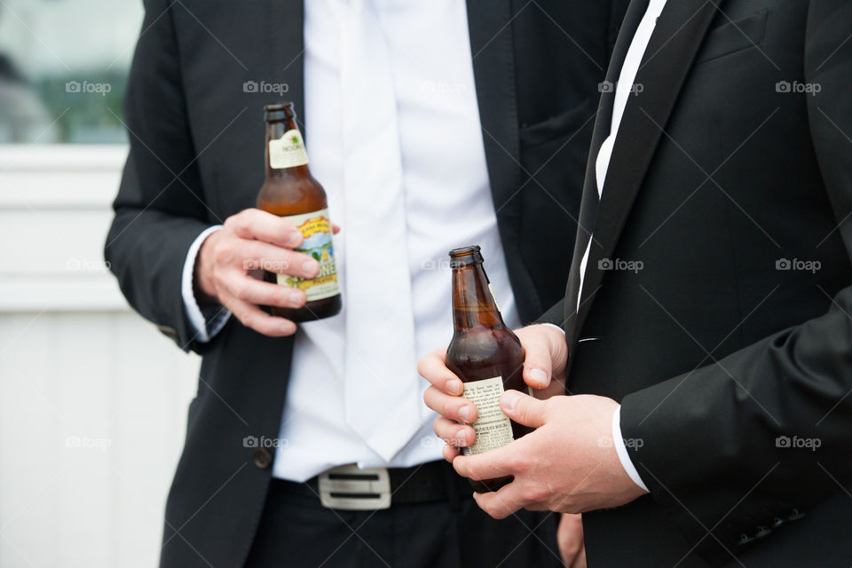 Two men in costume at a party holding a beer.
