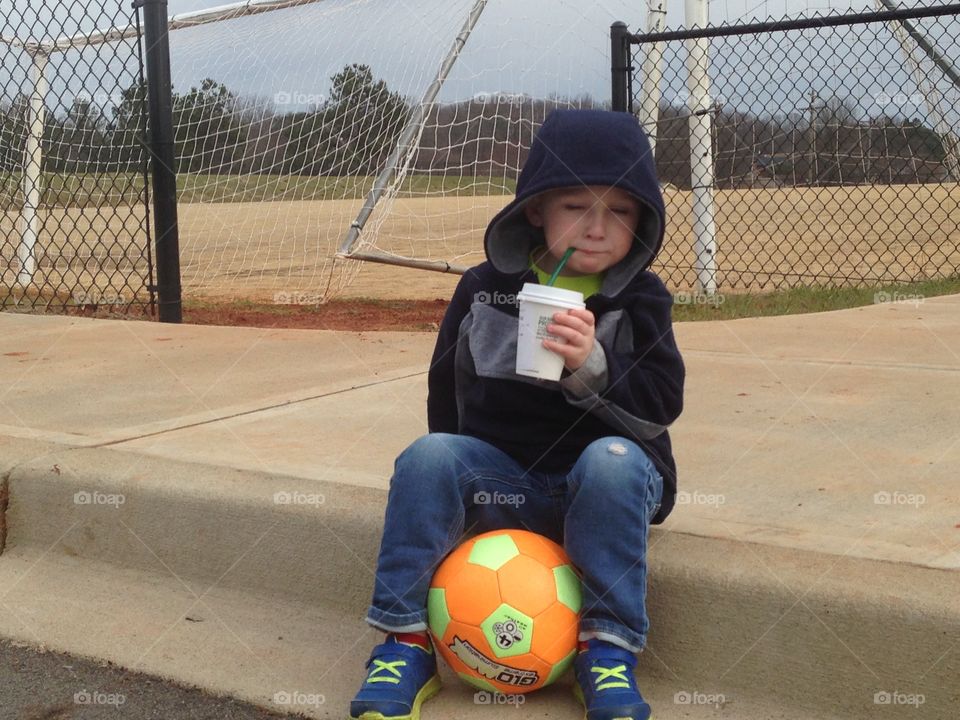 Kid, a ball, and hot chocolate 