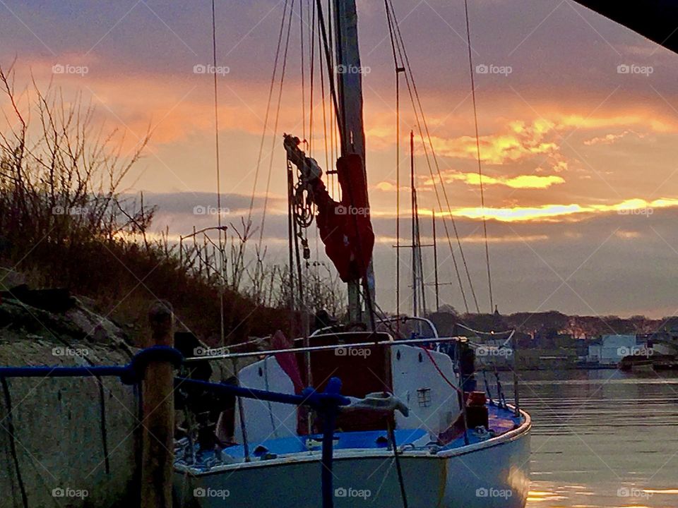 The “Salvation”, our sailboat is seen here in the foreground set against the water of the East River at Newtown Creek in Long Island City, Queens, NY photographed on a late afternoon in 2018 at upcoming twilight time. Hypnotic Productions
