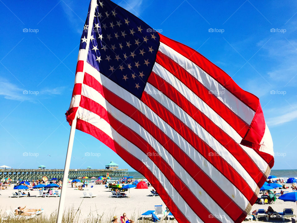 United States flag blows in the wind at the beach.