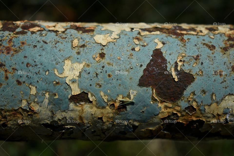 Rusted fence railing with chipped paint