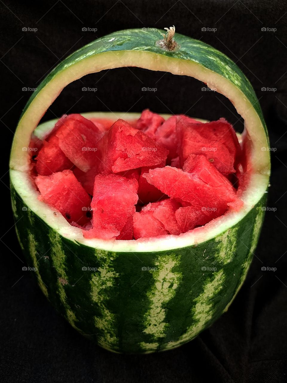 A basket of watermelon on a black background.
