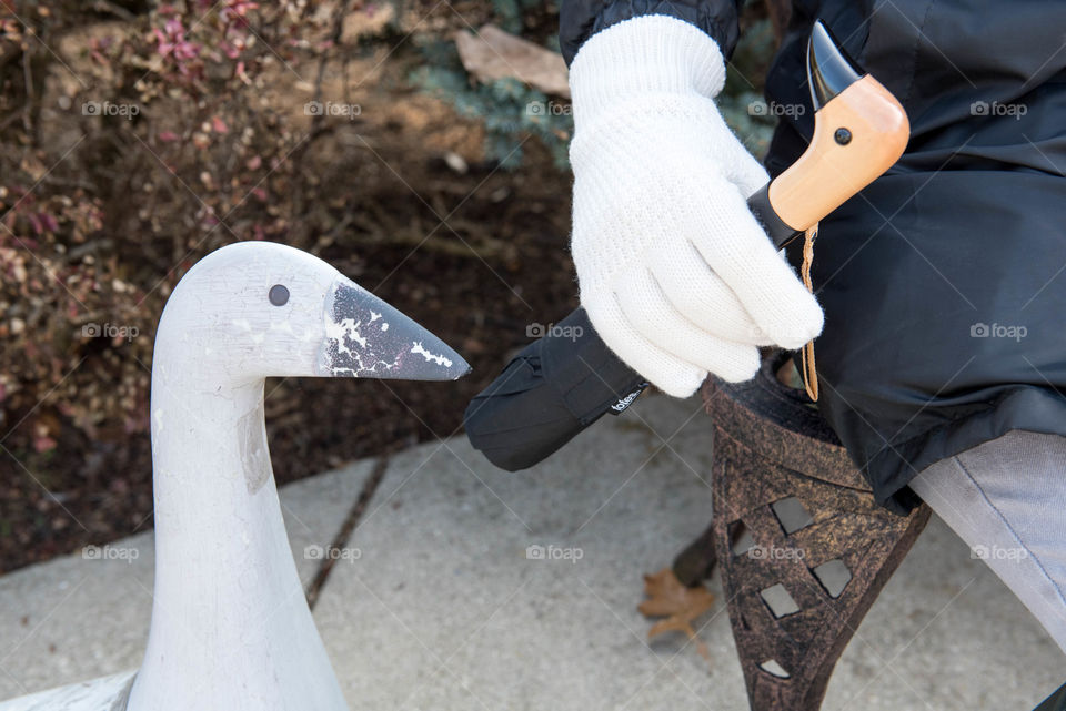 Close-up of a person's gloved hand holding a duck head handle umbrella outdoors