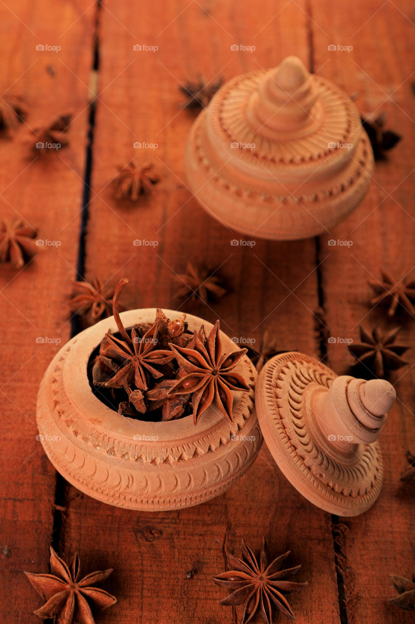 Star anise in a handmade mud pit on wooden background
