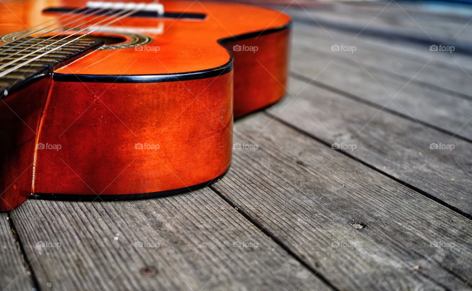 guitar orange color backgrounds wood shadow outdoors music musical instrument arts culture light close-up day