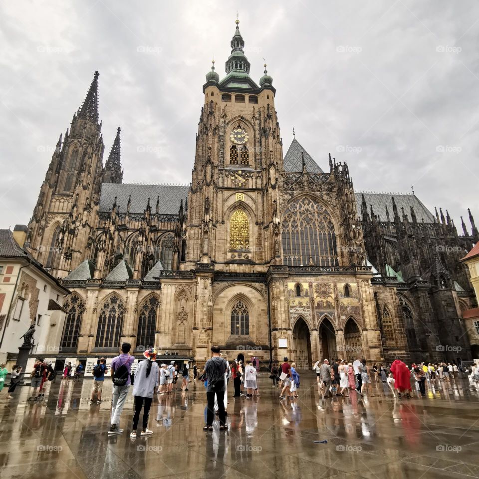 Travel time. Prague, Czech Republic. 
Rainy day in Prague city. People admiring the Prague Cathedral. 
Unusual shooting angle. Shooting from below. Down up. From the ground up...
