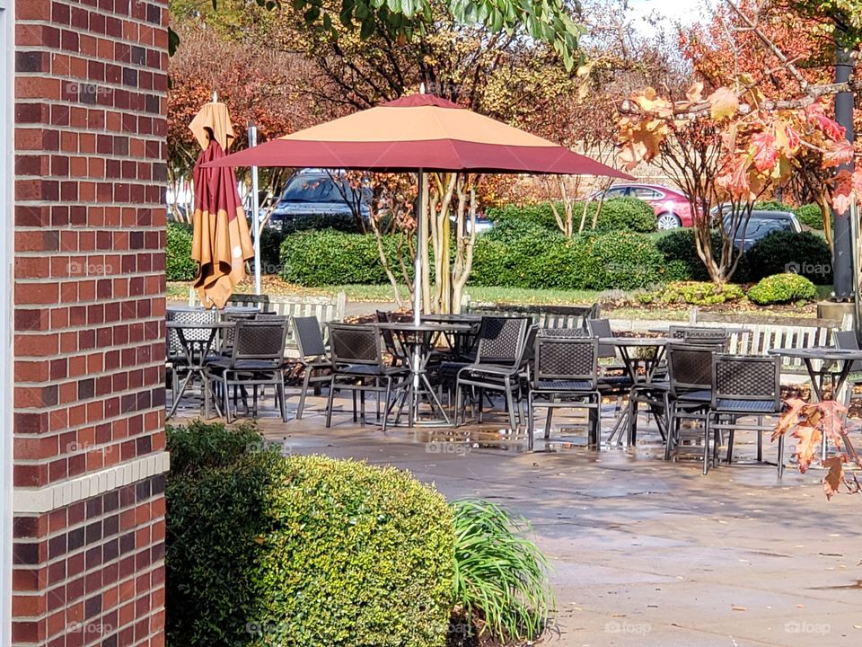 A beautiful autumn outdoor black, steel patio with umbrella from Panera Bread