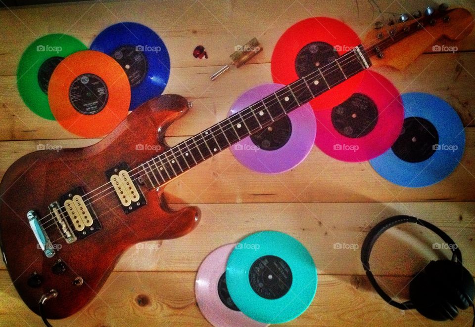 Electric guitar and old coloured vinyl records. Electric guitar and old coloured vinyl records