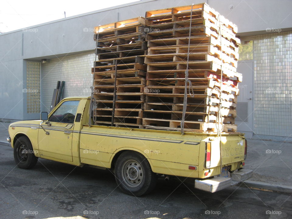 Yellow Toyota Truck. Yellow Toyota truck with pallets stacked in the back.