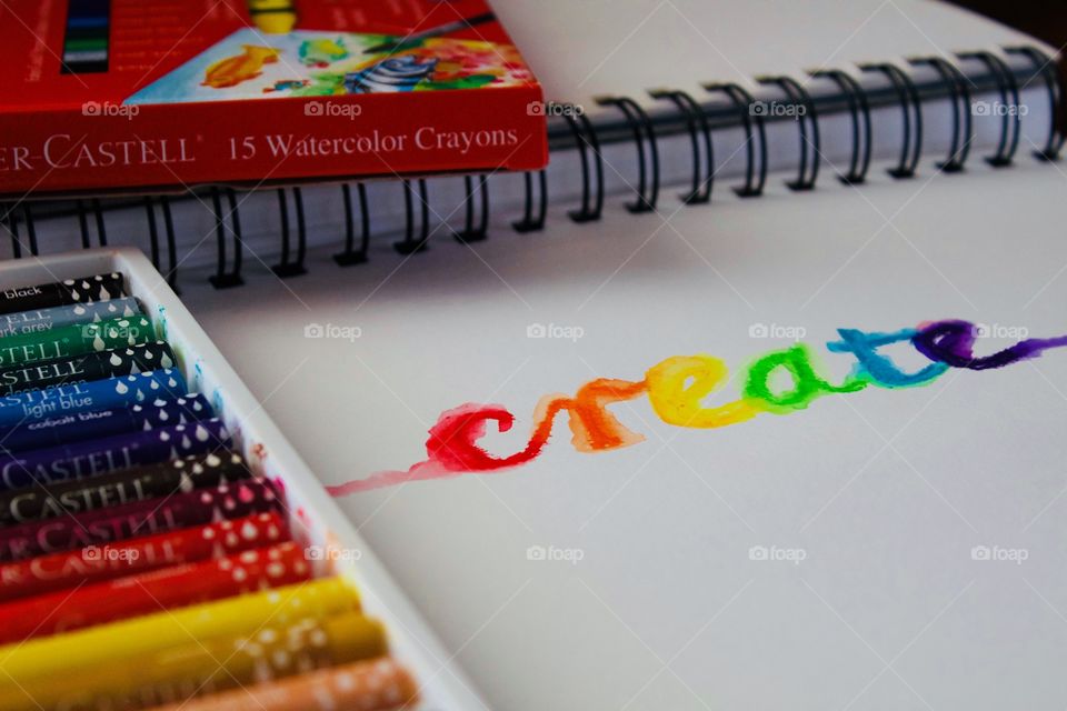 Colours of the World - watercolor crayons in white plastic tray, product box, watercolor and the word “create” in rainbow colors on mixed media wire-bound paper