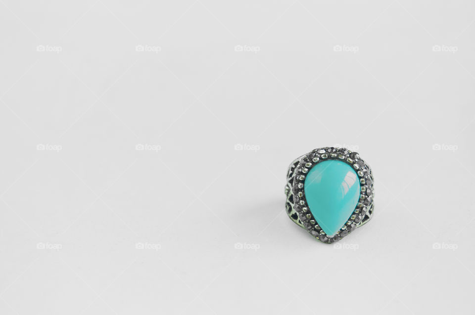 Turquoise ring on gray background with copy space 