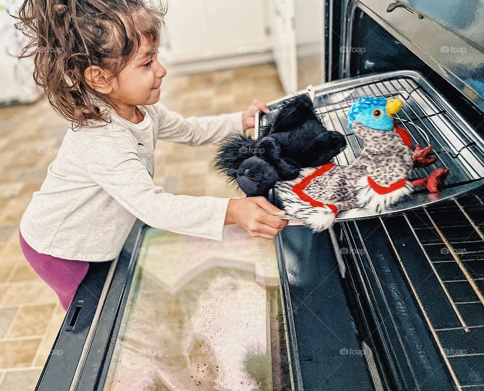 Toddler girl puts stuffed turkey and squirrel in the oven, making Thanksgiving dinner with mommy, funny toddler antics in the kitchen, making meals with mommy, stuffed animals going into the oven