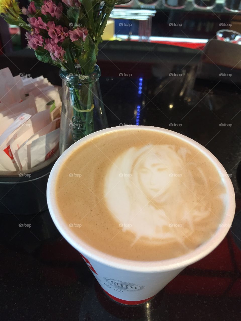 A women's face in the foam of a latte
