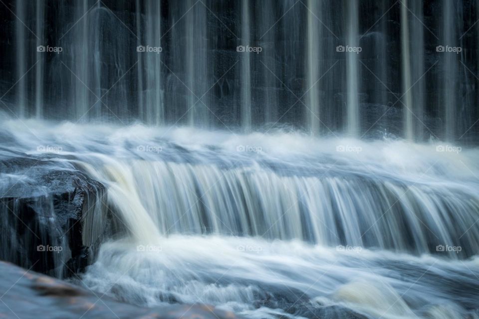 A hypnotic display of smooth cascading water descending a the falls at Historic Yates Mill County Park, Raleigh, North Carolina. 