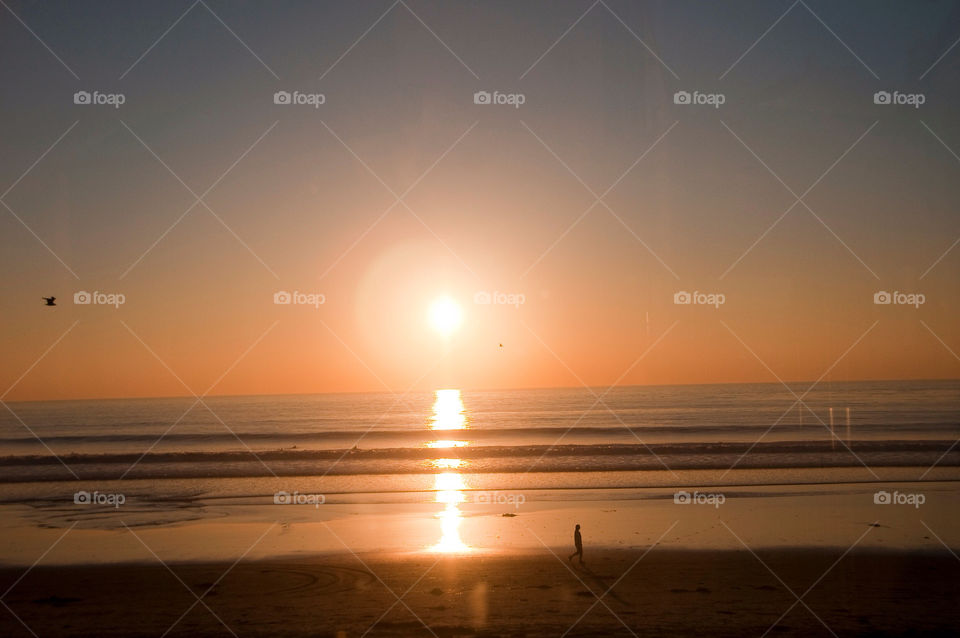 People playing in the sand of the California beach at sunset