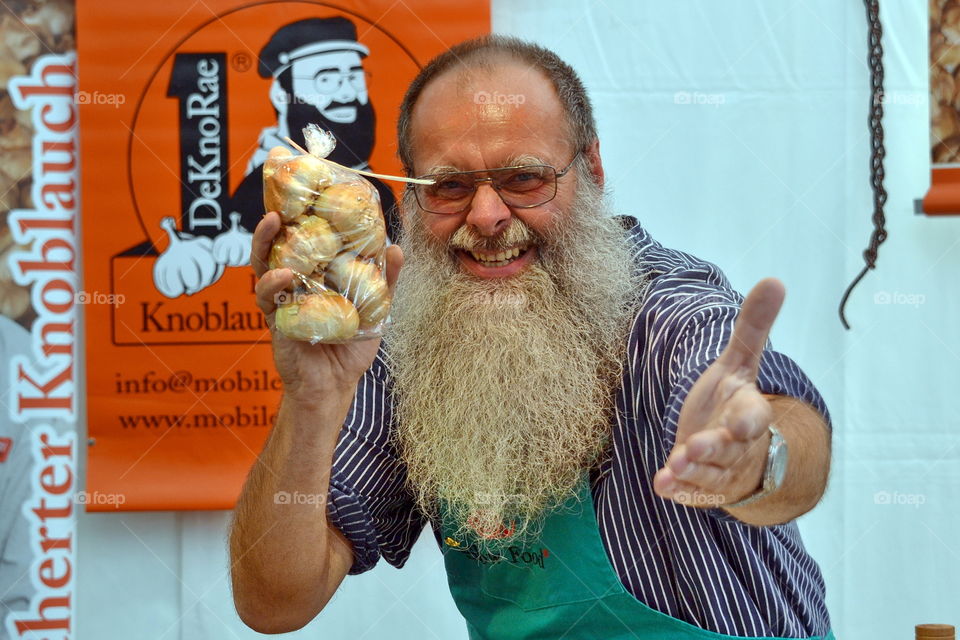 a funny bearded man invites the public to buy smoked garlic