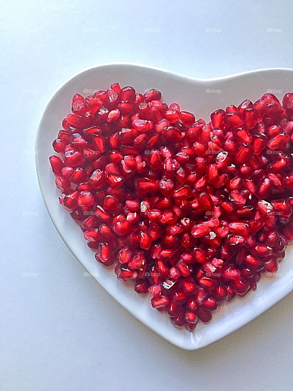Pomegranate seeds in heart shaped plate 